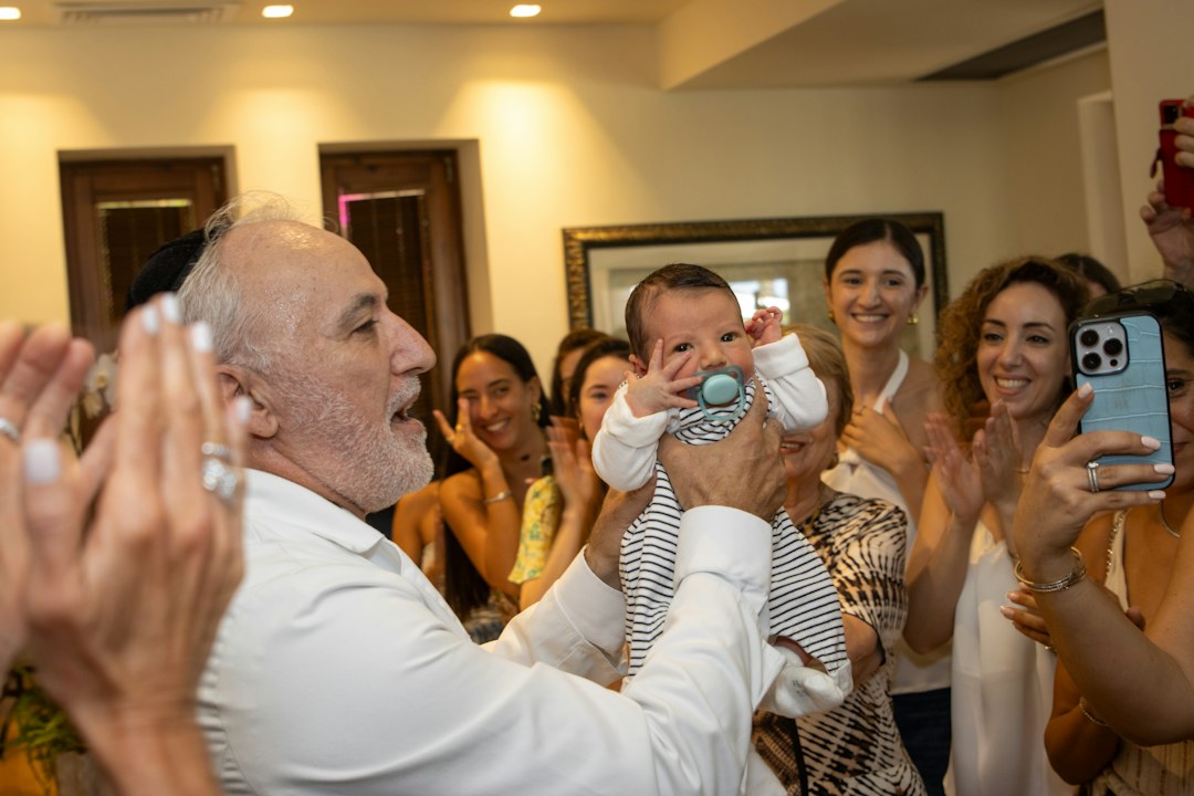Happy father holding a baby surrounded by smiling family