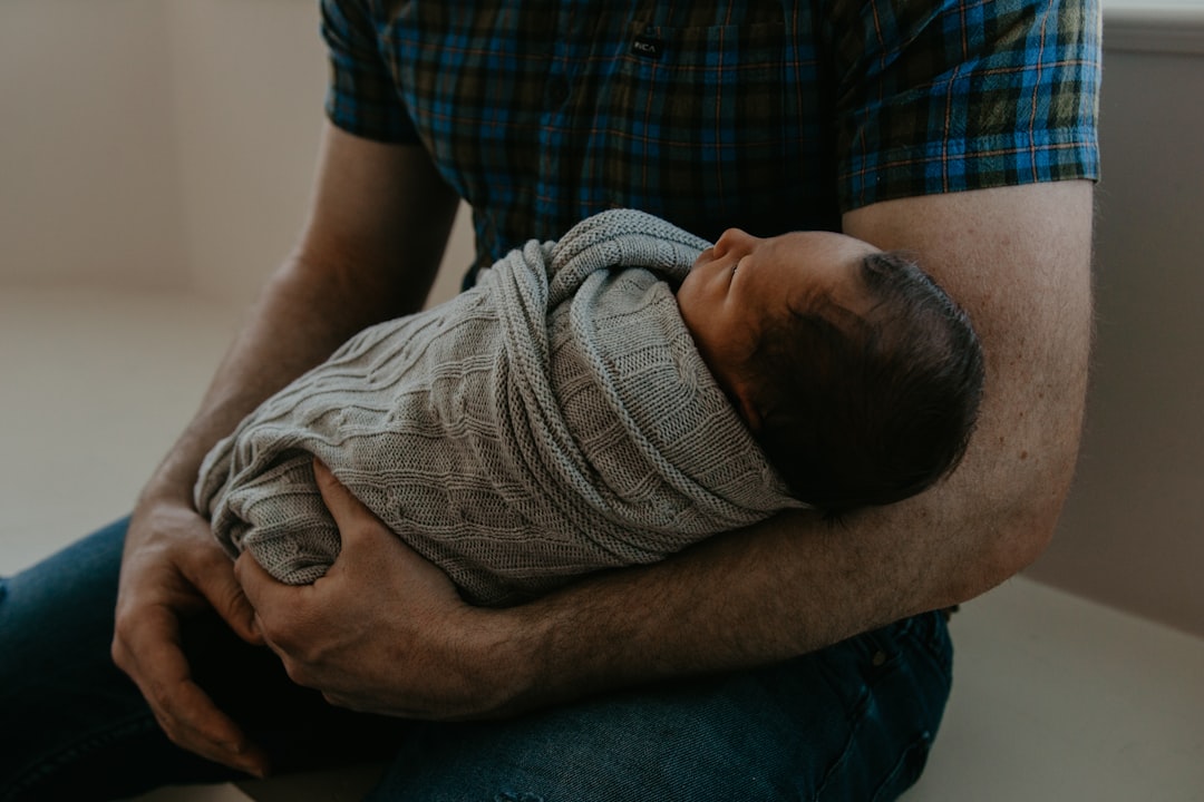 Father holding a newborn baby at home