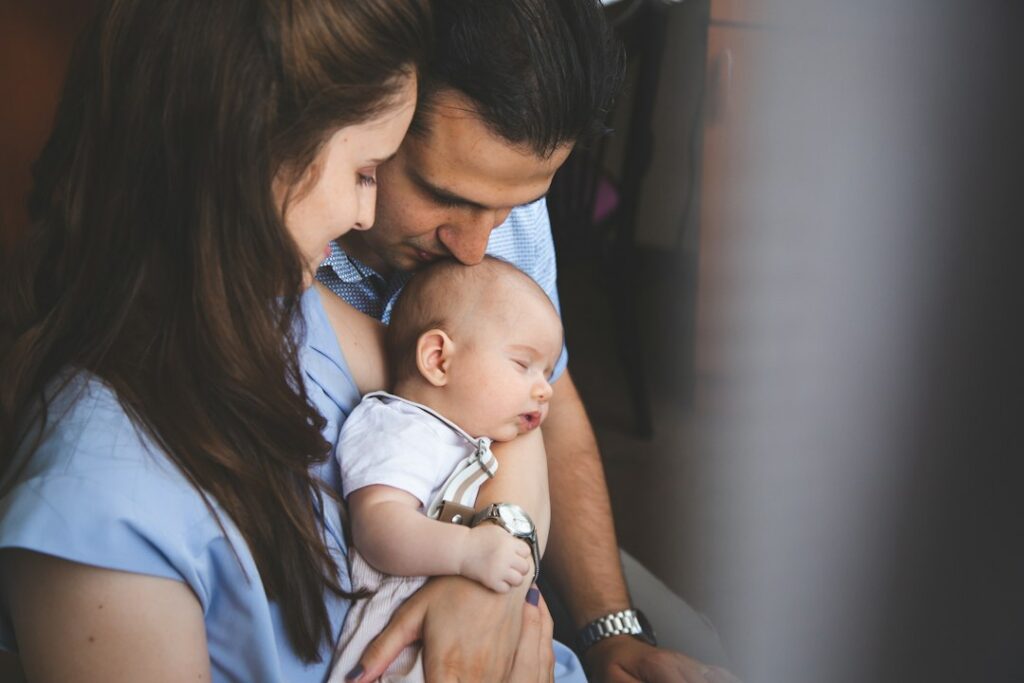Parents holding their sleeping baby boy