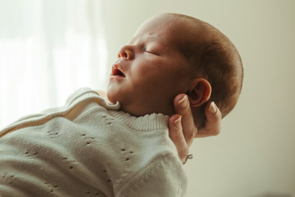 Newborn baby sleeping peacefully in a parent's arms